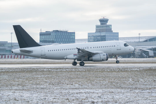 Generic white unbranded Airbus A319 passenger airplane on snowy airport runway in winter