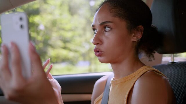 Annoyed mad African American woman talking mobile phone video call inside car frustrated female driver businesswoman girl chatting cellphone online gossip automobile transport auto problem complain
