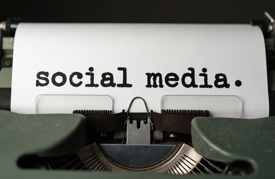 Social media text typed on vintage typewriter. Old machine and paper create retro feel. Concept of past communication methods meeting modern topics. Timeless connection.