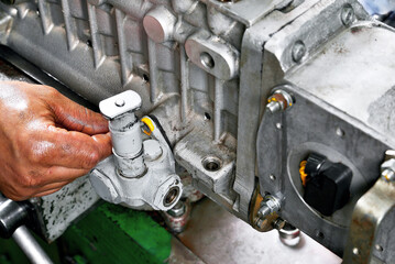 Fototapeta premium repair of fuel pump of eight-cylinder diesel engine installation of equipment and attachments on pump body