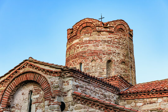 Ancient brick church with tower against clear blue sky