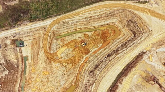 A construction site features heavy machinery digging and moving soil in a large area. The work alters the landscape and shapes the terrain.