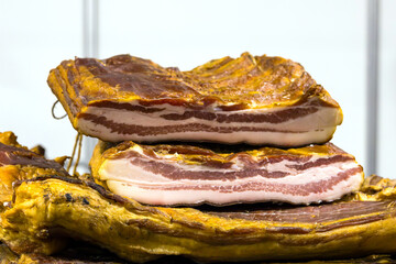 Dry homemade cured smoked bacon sold outside on local market