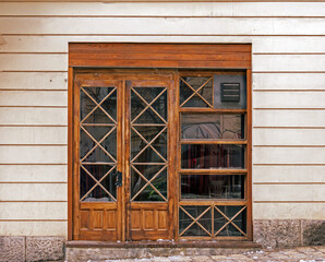 Retro closed store window with wooden frame outside on a street