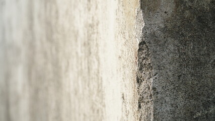 Obraz premium Detailed view of an old cement wall edge with chipped plaster and coarse surface