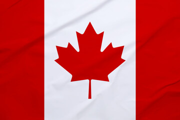 Obraz premium Flag of Canada with maple leaf on crumpled paper as background
