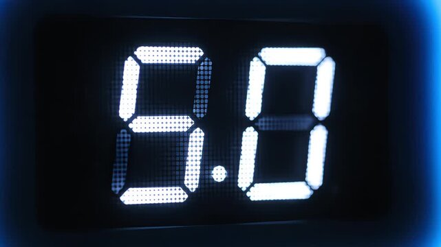 Close-up of digital LED display screen showing glowing white numbers 6.0 and 5.0 with blue futuristic light effect and decimal point