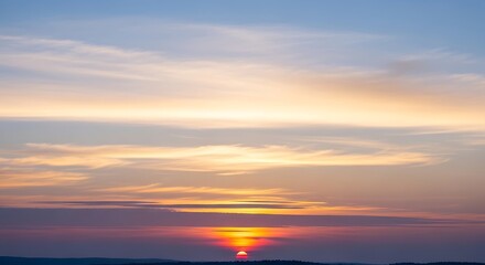 Vibrant sunset sky with a prominent glowing sun and colorful clouds over a distant horizon