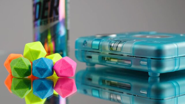 Retro blue gaming console with colorful geometric shapes on reflective surface