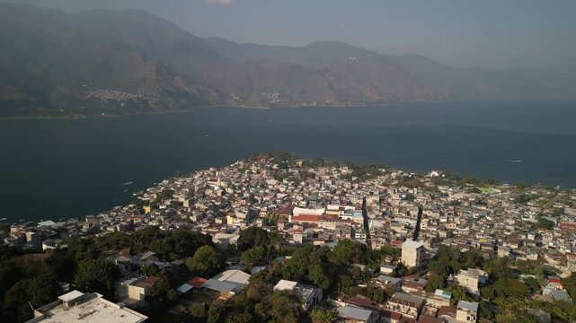 Aerial of San Pedro La Laguna town on Lake Atitlan hazy sunset in Guatemala