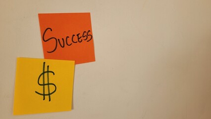 Success and money symbol on sticky notes, representing financial achievement and goals