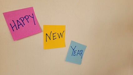 Happy New Year message written on colorful sticky notes attached to a wall