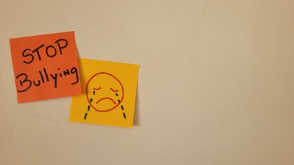 Stop Bullying message on sticky notes with sad face drawing