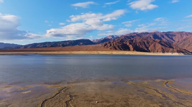 Aerial perspective reveals tranquil shallows of Orto Tokoy artificial lake nestled among barren mountains. Autumn 2025.