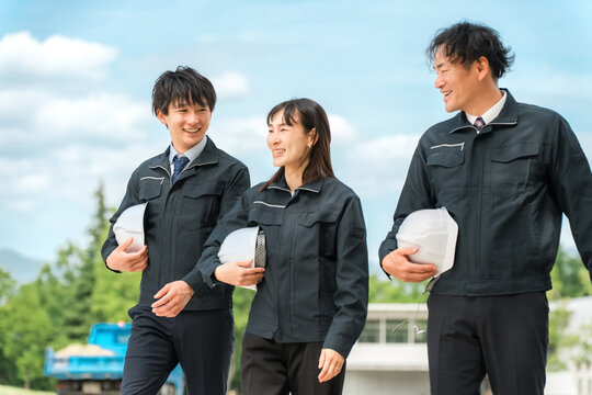 作業現場を歩く作業着姿の男女の作業員（建築業,運送業,土木業,ゼネコン）