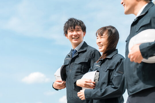 Male and female workers in work clothes walking at the work site (construction industry, transportation industry, civil engineering industry, general contractor)