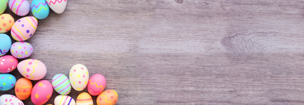 Colorful Easter Egg corner border against a wood banner background. Above view with copy space.
