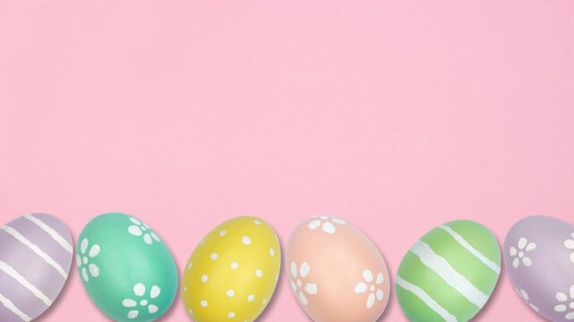 Colorful dancing Easter Egg bottom border on a pink background. Stop motion. Copy space.
