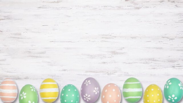 Colorful Easter Egg bottom border on a white wood background. Up down, stop motion. Copy space.