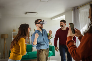 Naklejka premium Friends enjoying virtual reality gaming experience at home