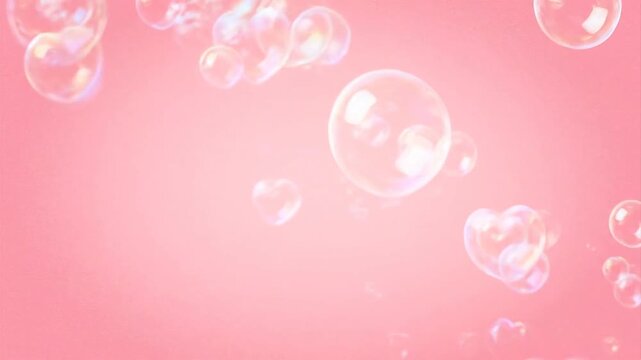Iridescent soap bubbles floating gently in the air on a soft pink background from a close-up viewpoint