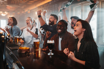 Diverse sports fans cheering watching soccer game in pub © Zamrznuti tonovi