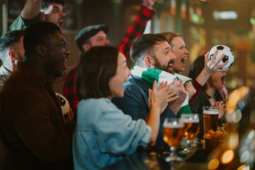 Diverse soccer fans watching game and celebrating victory in bar © Zamrznuti tonovi