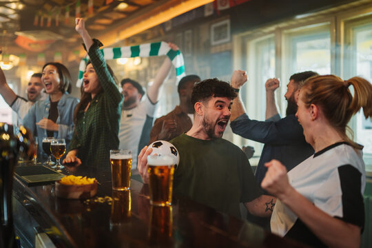 Excited sports fans celebrating victory watching soccer match