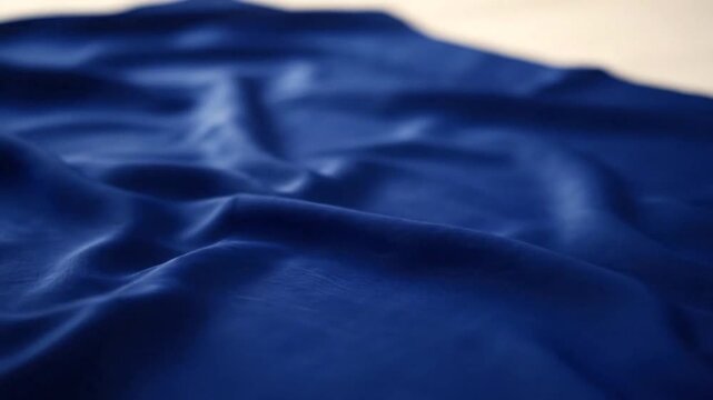 Close-up of blue fabric with soft folds and creases.
