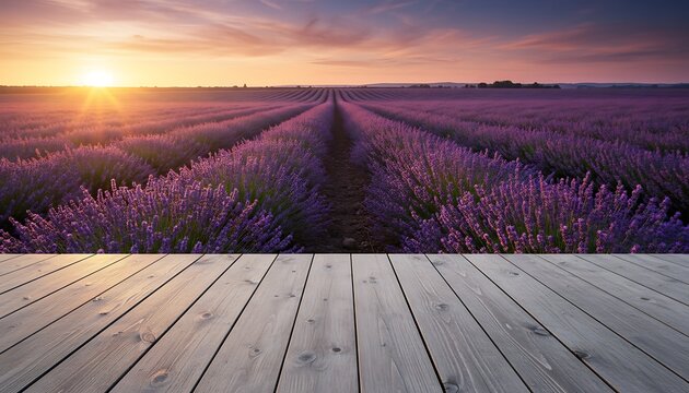 Scenic vista of a vast lavender field, sun setting behind distant mountains. Wooden deck in foreground
