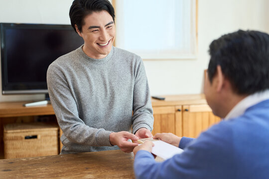 笑顔でお金を受け取るアジア人男性