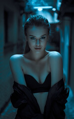 A dark-haired woman, wearing black lingerie, poses artistically.