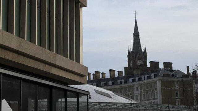 A scenic urban view of the historic Victorian Gothic station tower adjacent to the modern glass and timber landscraper architecture of the Google headquarters in the heart of London