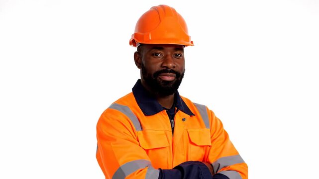 Confident Construction Worker Portrait - A confident-looking African American construction worker with a beard is wearing a bright orange safety helmet and high-visibility jacket with his arms