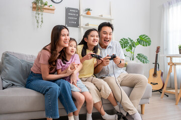 Asian happy family enjoying games with their little girl daughter.