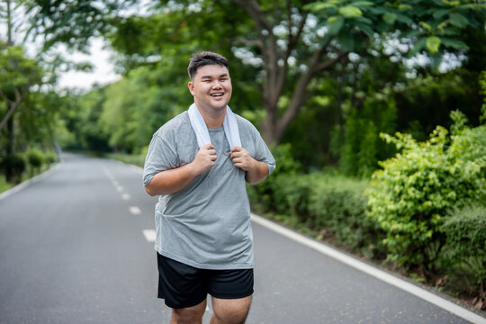 Asian plus-size man exercises outdoors in the garden to lose weight. 