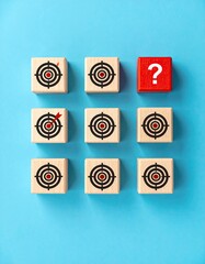 Wooden blocks with bullseyes and a question mark, on blue