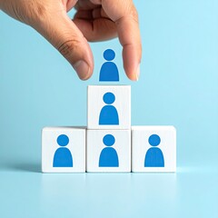 Hand arranging blue figure blocks in a pyramid, promoting upward growth