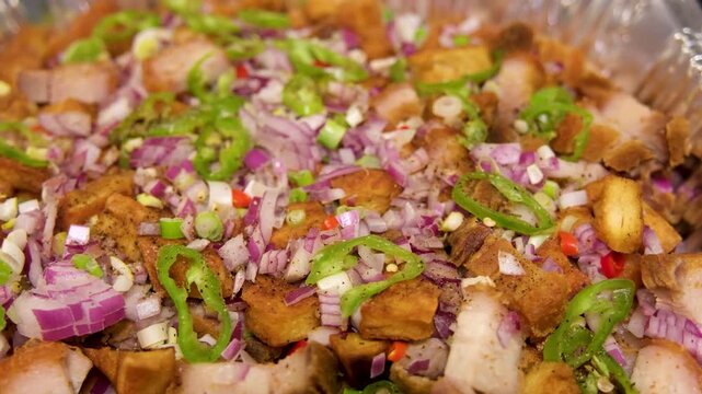 Tokwat baboy preparation in the Philippines with crispy pork and fresh vegetables
