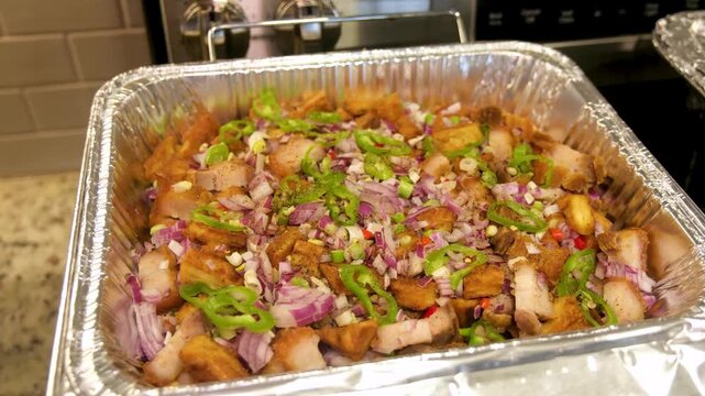Tokwat baboy preparation in the Philippines with crispy pork and fresh vegetables
