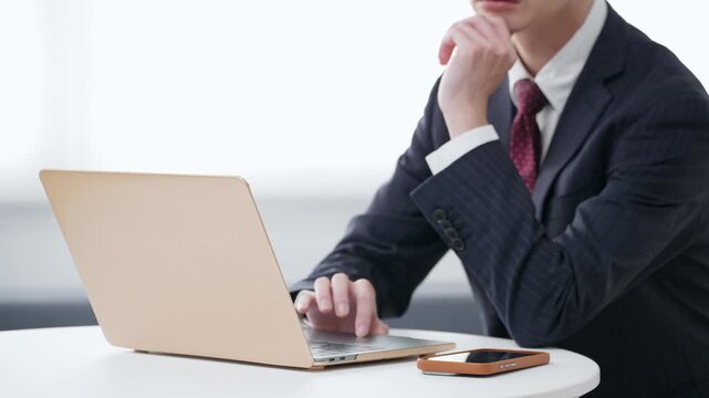 オフィスでノートパソコンを使う男性ビジネスパーソン