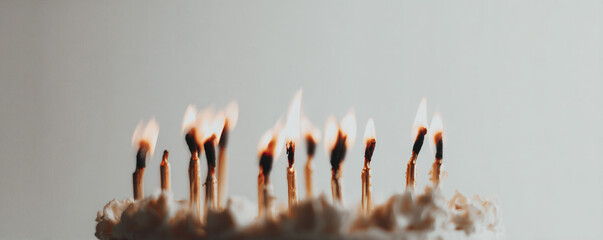 Low-angle close-up of candle flames against white backdrop, cake minimally visible 32k