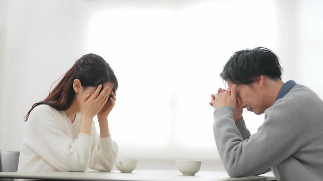 部屋で落ち込む男女カップル