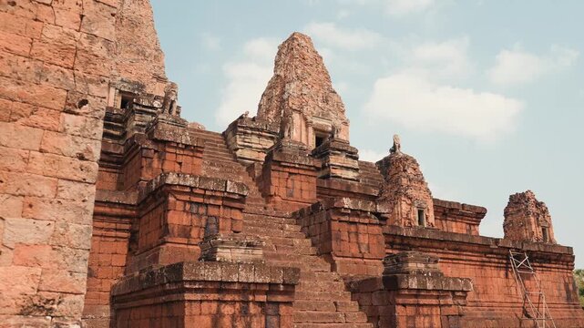 Detailed view of Banteay Samre Temple in Angkor Cambodia showing ancient sandstone towers, carved stone steps, historic Khmer architecture, and clear daytime sky