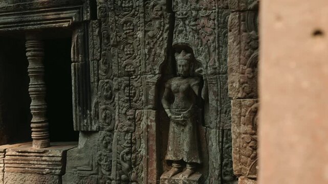 Closeup view of Angkor Wat in Cambodia featuring detailed stone relief carvings, devata sculpture, temple wall textures, and ancient Khmer architecture