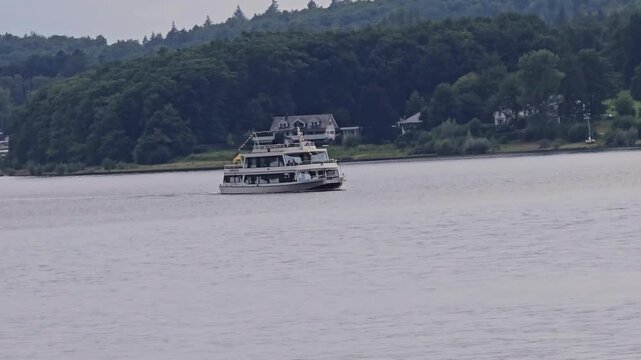 Excursion boat on Lake Sorpe in the Sauerland region: A white passenger ship sails along a wooded shore.