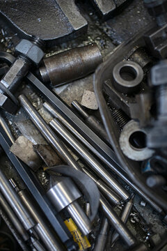 Close-up view of various metal machine parts and tools in a workshop setting