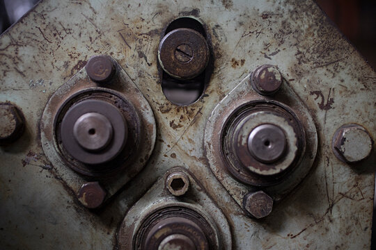 Close-up of weathered industrial machinery with bolts and bearings