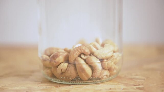 Cashew nuts falling into a jar. Superfood, plant based ingredient