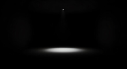 Dark empty room with a single bright light illuminating the floor.